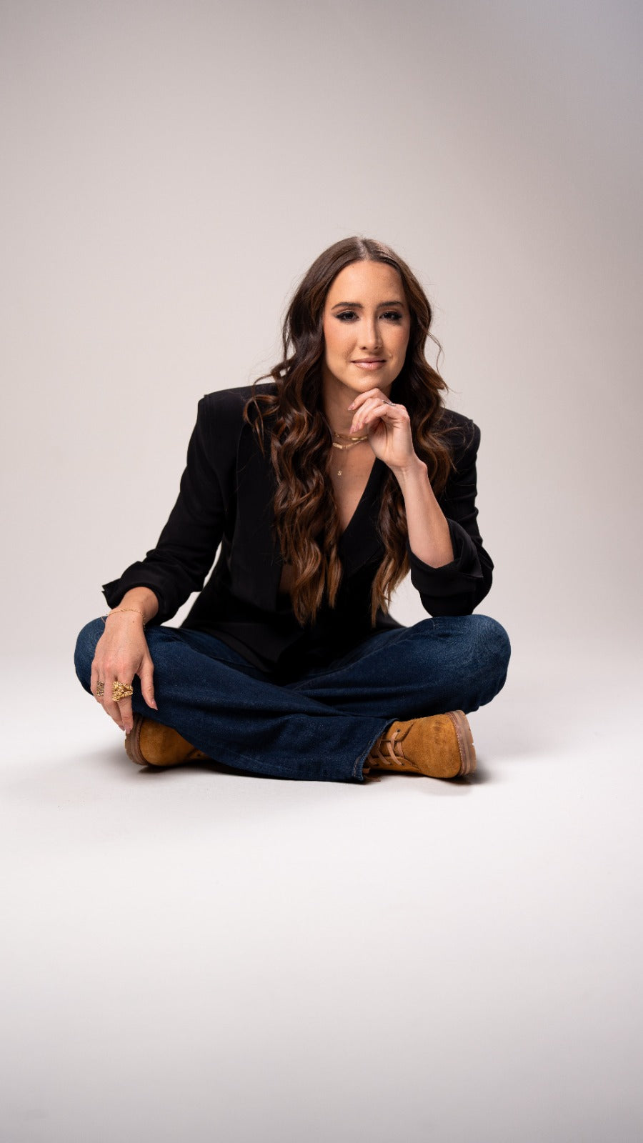 Codie Sanchez seated in a black blazer for a studio portrait.