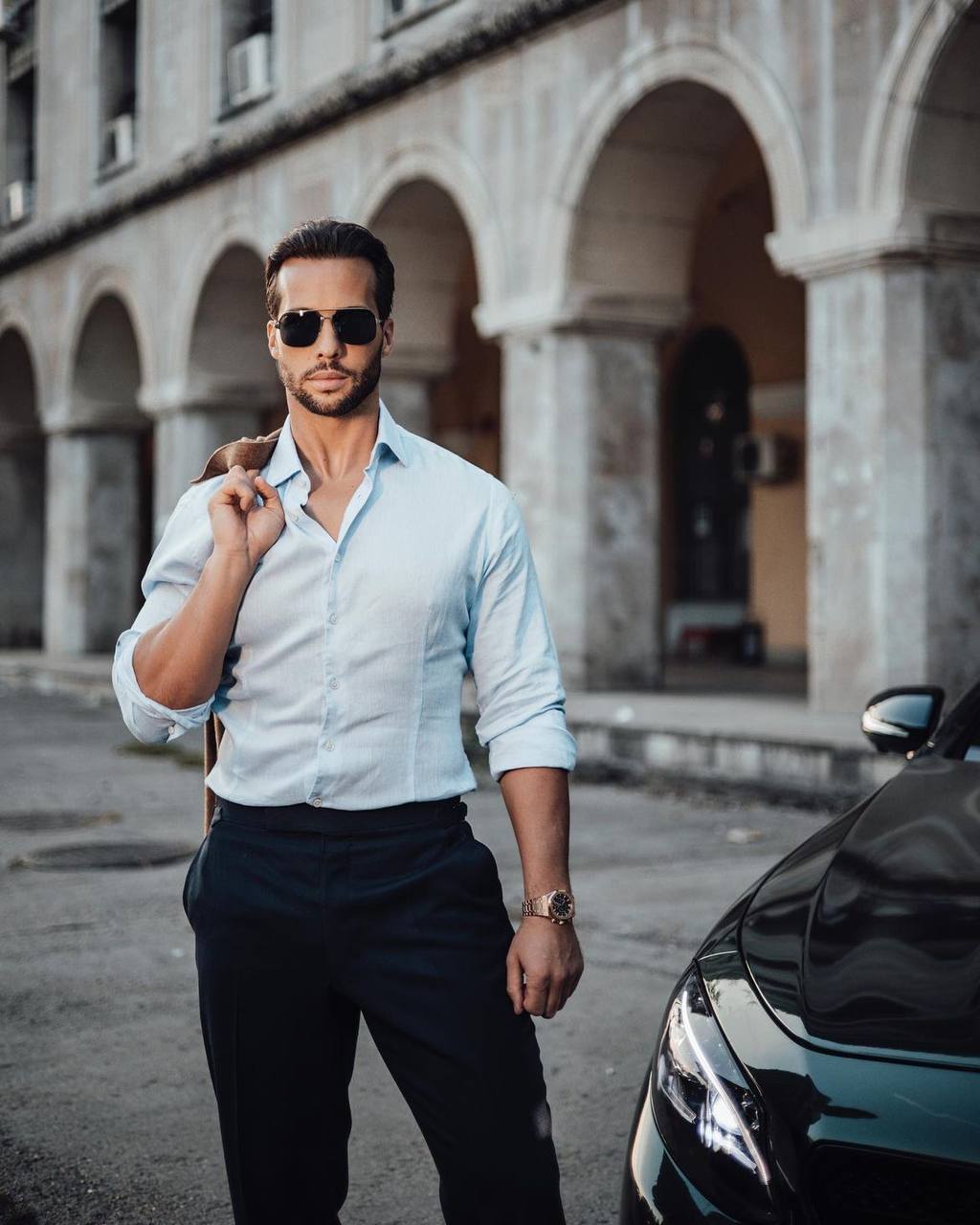 Tristan Tate in a white shirt outdoors.